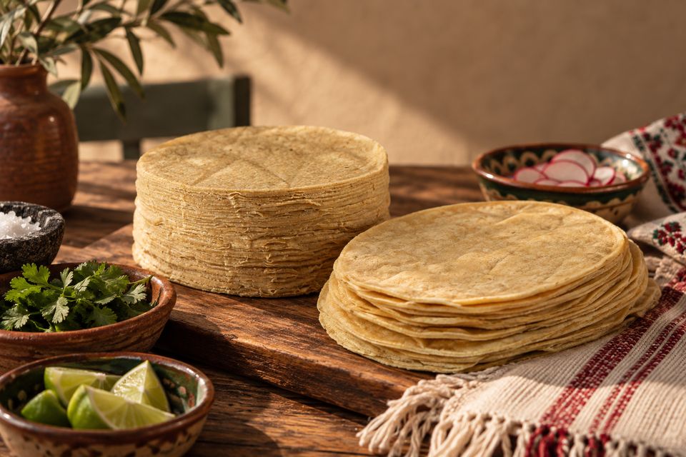 Pilas de tortillas de maíz AYALA con limón y hierbas frescas